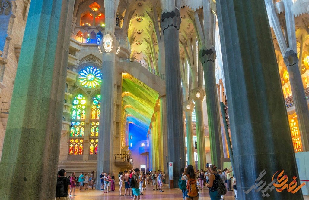 درون کلیسای ساگراد فامیلیا Sagrada Família ، فضایی است که نور طبیعی به زیبایی از پنجره‌های رنگی عبور می‌کند و فضایی روحانی ایجاد می‌کند.